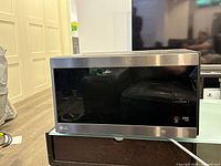 Front view of LG Smart Inverter microwave showing stainless steel and black glass design