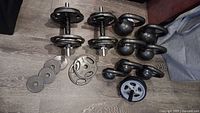 Overall view of kettlebells, adjustable dumbbells, plates and ab roller