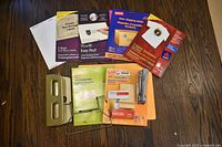 All items spread on table: various label packs, hole punch, stand, stapler visible