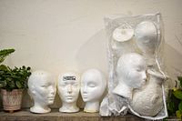 Full lot showing three loose Styrofoam heads and sealed bag containing additional heads