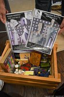 Overview of crate with paper sculpture kits, gel pens, ink pads and stamps visible