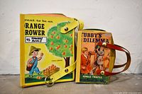 Front view of both book purses showing illustrated covers and belt handles