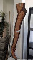 Full view of tall live edge board leaning against wall