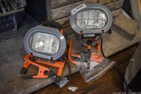 Two HDX work lights with clamps and ground stake accessory on hearth
