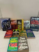 Photo showing 11 books grouped with visible titles by James Patterson, Janet Evanovich, Tom Clancy.
