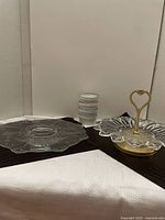 Two glass serving trays and four stacked creme brulee dishes shown from a distance