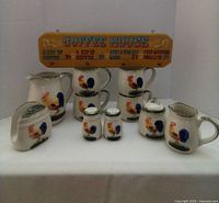 Full view of matching rooster coffee set with 4 mugs, sugar and cream dispensers, napkin holder, salt and pepper shakers, water jug, and Coffee House sign.