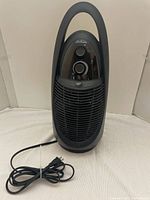 Front view of Sunbeam portable heater showing control panel and grille with attached power cord.