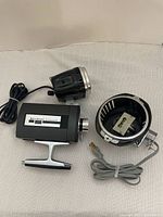 Bell and Howell movie camera body with two detachable flash attachments and their cords.