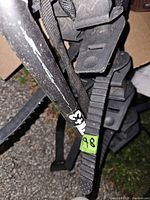 Close-up of bike carrier strap and frame showing wear and quick-release buckle mechanism.
