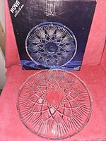 Bohemia crystal Lyra Nova Collection plate displayed in front of its original box showing the design and packaging.