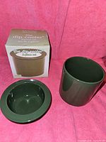 Box and both ceramic components of the dip cooler shown on pink fabric background.