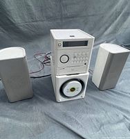 Front view of stereo system showing main unit stacked on subwoofer and two satellite speakers