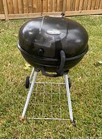 Closed grill on stand showing overall form and wheels