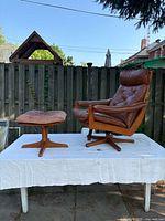 Front view of recliner and ottoman set on white cloth outdoors