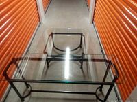 Top-down view of the rectangular glass top table showing metal frame and glass thickness.