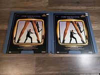 Two vinyl records of the James Bond movie soundtrack 'For Your Eyes Only' with cover showing a man with a gun framed by legs.