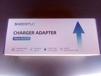 Photo of the ShockFlo Charger Adapter box featuring product name, compatibility, max amperage and voltage, and ingress protection rating.