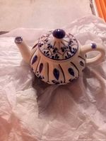 Top view of vintage Chinese ceramic teapot with lid on, showing blue floral and fish motif decoration.