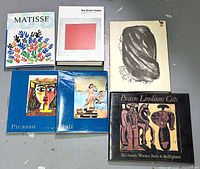 All six art books arranged on floor, showing covers with bold colorful art styles including Matisse, Guggenheim, Picasso, Dali, and Picasso Linoleum Cuts
