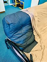 Close-up photo of the black futon mattress with beige fitted cover showing fabric texture and coverage.