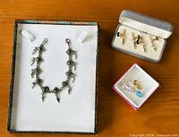Overview of all items: silver-tone bracelet, cufflinks in original Lord West box, and loose gemstones in small box