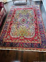 Full view of entire rug laid on hardwood floor next to furniture