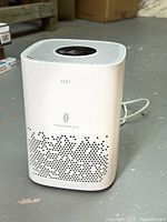 Front view of the white TaoTronics air purifier showing vent holes and logo.
