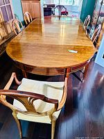 Full view of dining table with one armchair at near end and two side chairs at far end