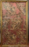 Full frontal photograph of vintage tapestry in glass frame, showing intricate bird and flower pattern on a red background within a gold-finished wooden frame.