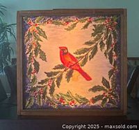 Front view of the illuminated glass framed artwork showing the red cardinal bird with holly decorations.