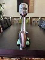 Front view of Myers Bullet Mixer with aluminum cup on dark wooden table, highlighting mixer head and base.