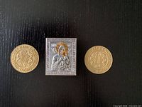 Photo of the three items: Russian icon of Mary and Jesus in the center, flanked by two Vietnam brass tokens.