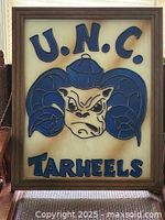Framed stained glass window showcasing UNC Tarheels ram mascot and lettering