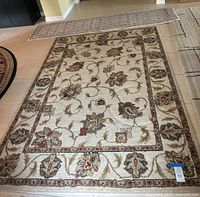Photo of the area rug and the runner side by side on tile floor, showing floral patterns and colors clearly.