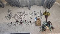 Full view of all 9 decorative metal wall art pieces and planters arranged on carpet showing variety of sizes and shapes.