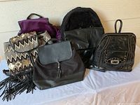 Five backpacks displayed on table front view