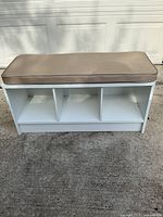 front view showing three open cubbies and cushion