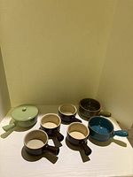 All bowls arranged: Parini set of four brown bowls, green lidded bowl, olive and teal bowls