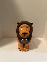 Front view of plastic lion cookie jar with ‘COOKIES’ label