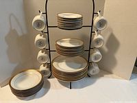 Overall view of stacked plates and hanging cups on stand