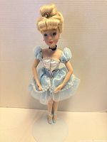 Full view of porcelain Cinderella doll on stand