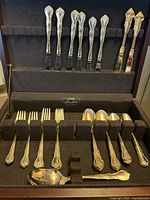 Flatware set arranged in wood chest