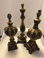 All three beige and silver decorative finials upright on white background