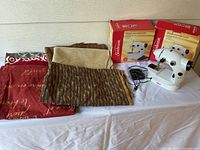 Two Sunbeam sewing machines, boxes, power cord, seven fabric pieces