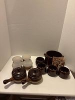All items grouped: bean pot, four bowls, four custard cups with lids, two covered crocks