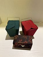 Two takeout-style boxes and closed brocade box