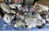 Wide view of mixed sewing notions in plastic bags including lace trims, zippers, and fabric pieces.