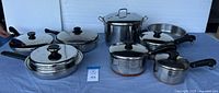 Full view of the 7 pots and pans arranged next to each other showing variety of sizes and lids
