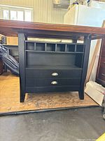 Front view of bar-height table showing storage base, drawers and wine cubbies